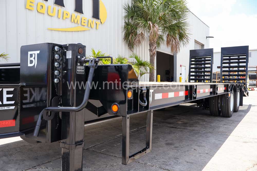 Built-in step and jack at the front of a Behnke 40,000 GVW flatbed trailer