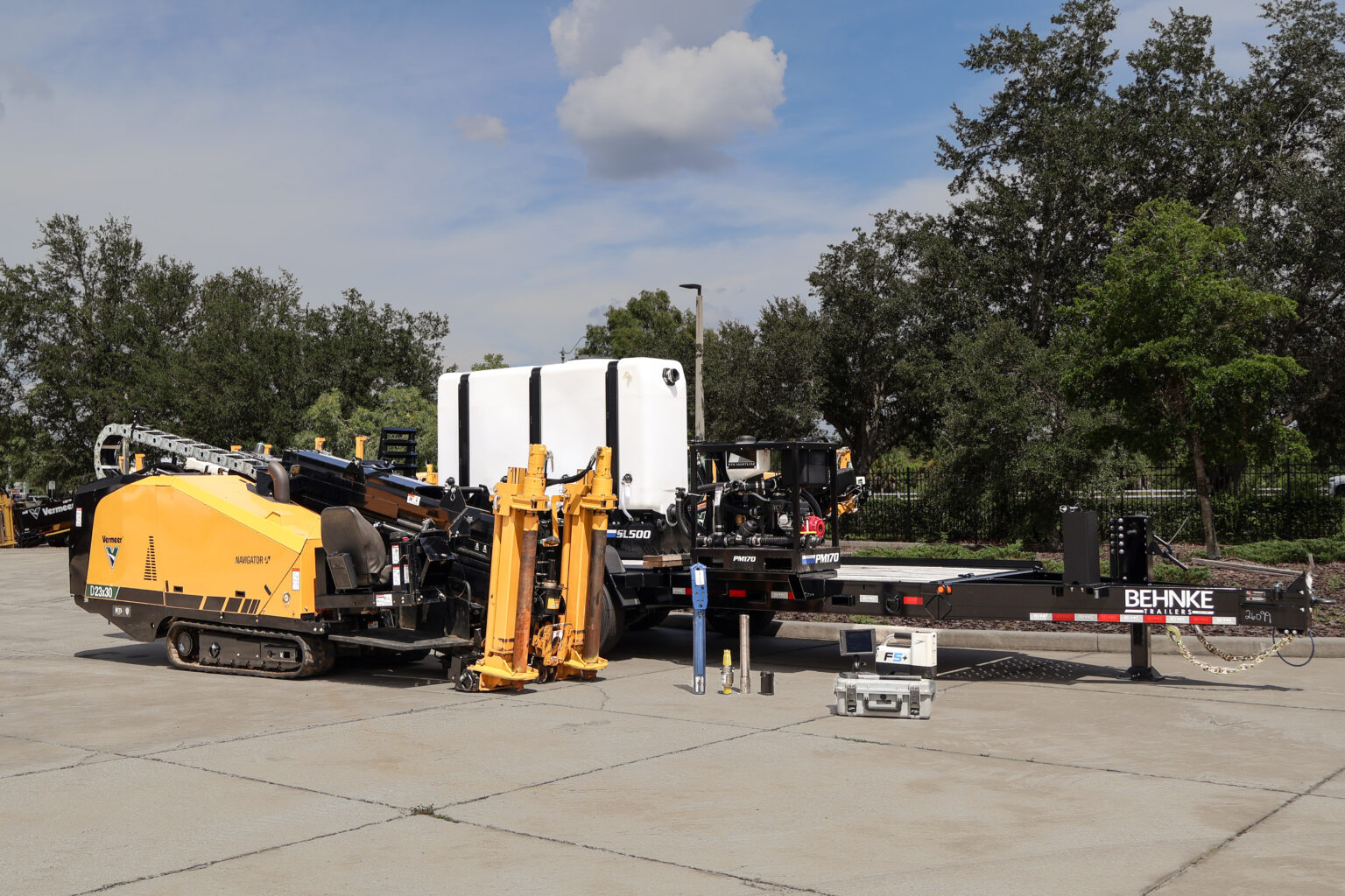 Vermeer D23x30 drill beside a new Behnke trailer loaded with a mud system, water tank, locator and tooling